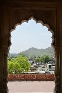 Scenic city and hill views framed by a beautifully carved marble arch at Moosi Maharani Ki Chhatri, Alwar, Rajasthan.