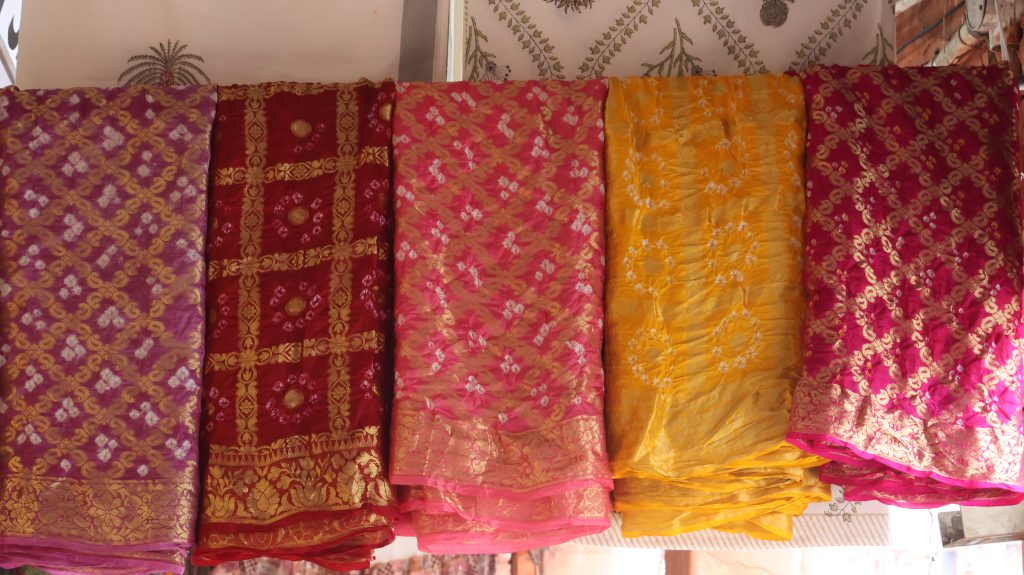 A row of five colorful Indian textiles displayed together at Bapu Bazar, Jaipur.