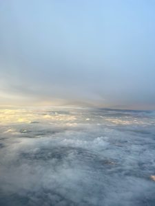 A view from an airplane window looking down at a vast expanse of clouds.
