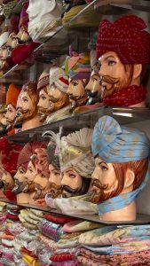 A shelf of mannequin heads with Rajasthani turbans displayed.