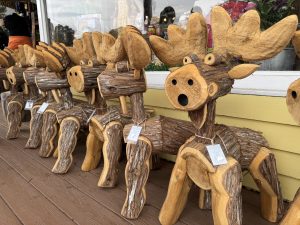 A row of moose sculptures made with logs on the front porch of Zeb’s General Store in North Conway, New Hampshire. 