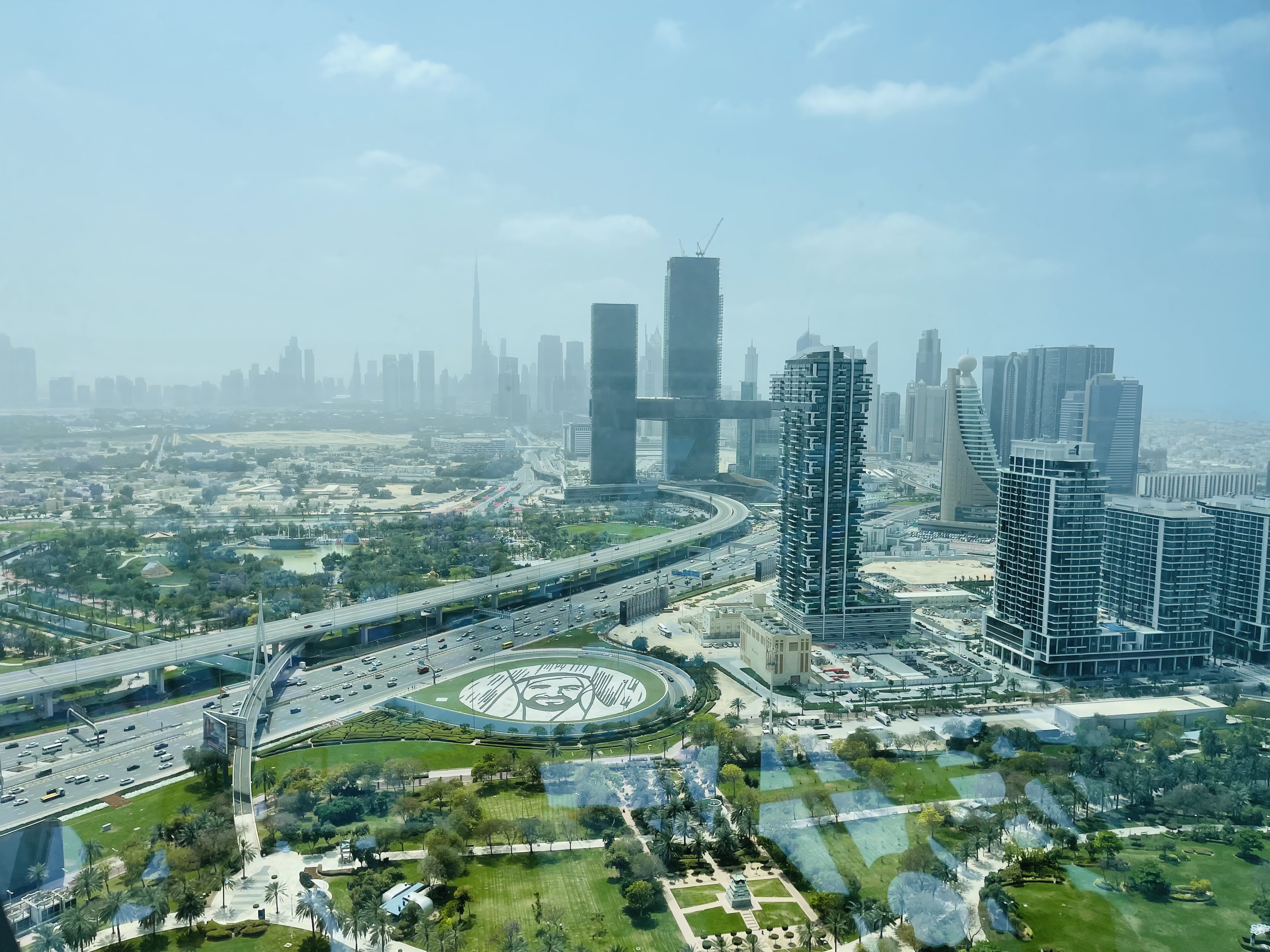 An aerial view of a sprawling city with skyscrapers, highways, and green spaces.