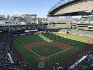 Wide view of Safeco Field in Seattle Washington with the field, scoreboard, and partially open retractable roof
