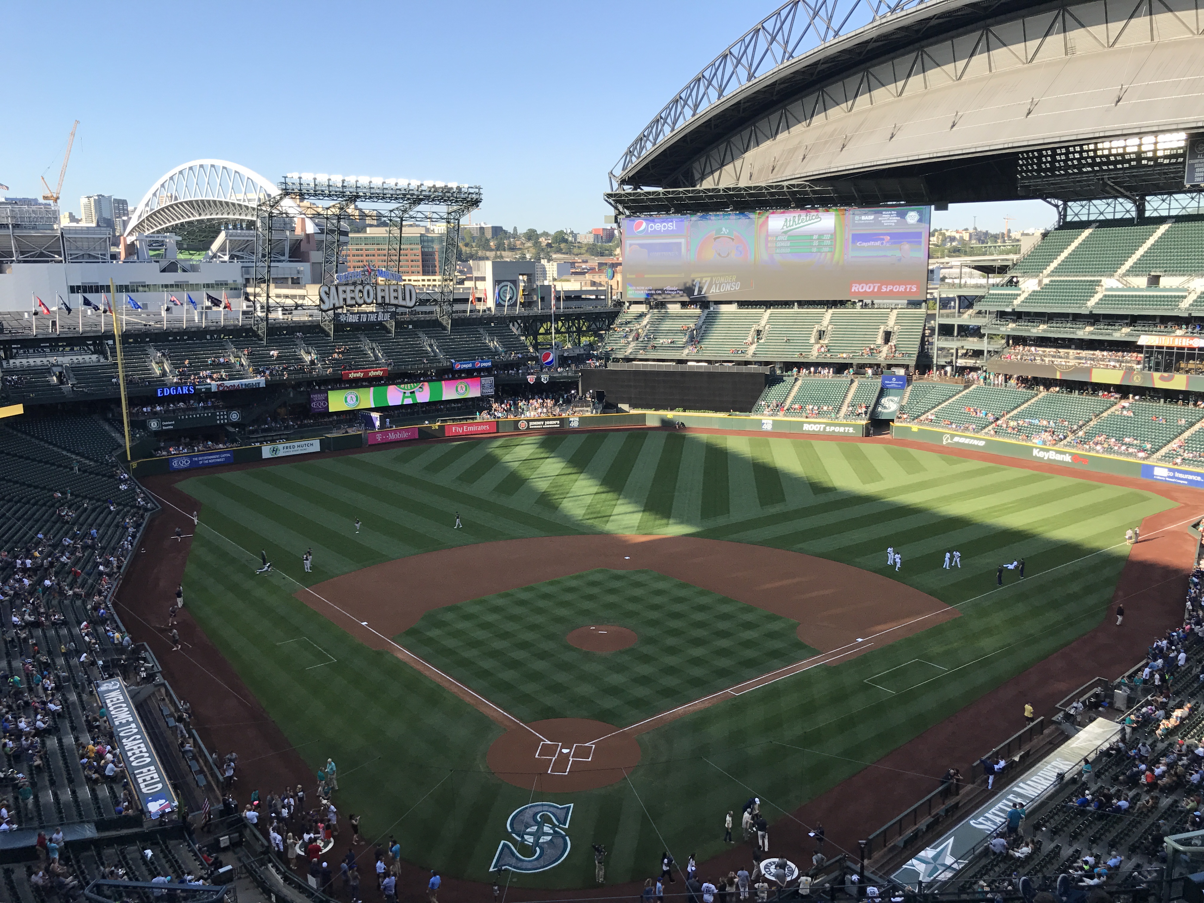 Wide view of Safeco Field in Seattle Washington with the field, scoreboard, and partially open retractable roof