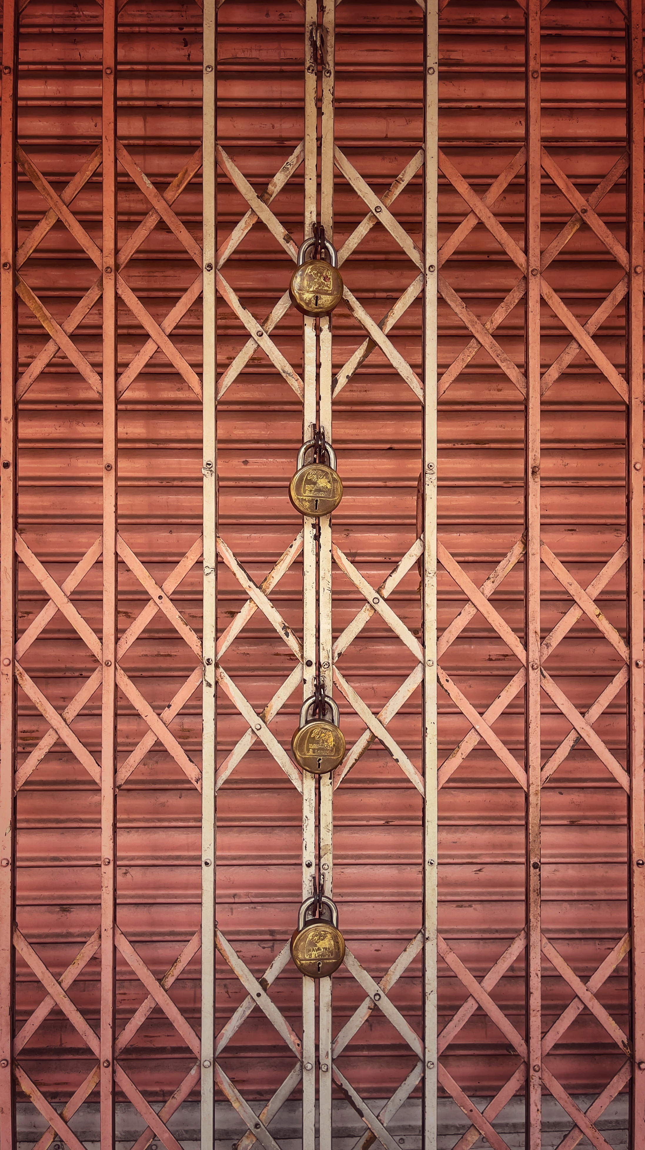 shuttered down shop locked with four padlocks on collapsible door.