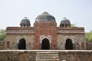 Front view of the mosque in Isa Khan’s Tomb Complex, Delhi, with intricate carvings, arched doorways, and colorful tiles in Indo-Islamic Delhi Sultanate style.
