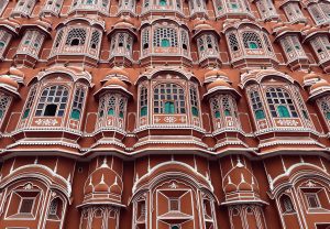 A close-up of the Hawa Mahal in Jaipur, India, showing its intricate latticework and ornate windows.