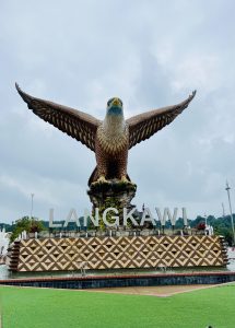 A large statue of an eagle with its wings spread, standing on a fountain base that spells out "LANGKAWI," in Langkawi, Malaysia.