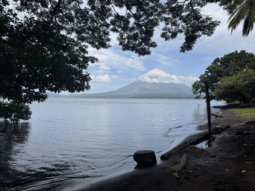 The towering Maderas Volcano rises peacefully over the calm waters of Lake Cocibolca.