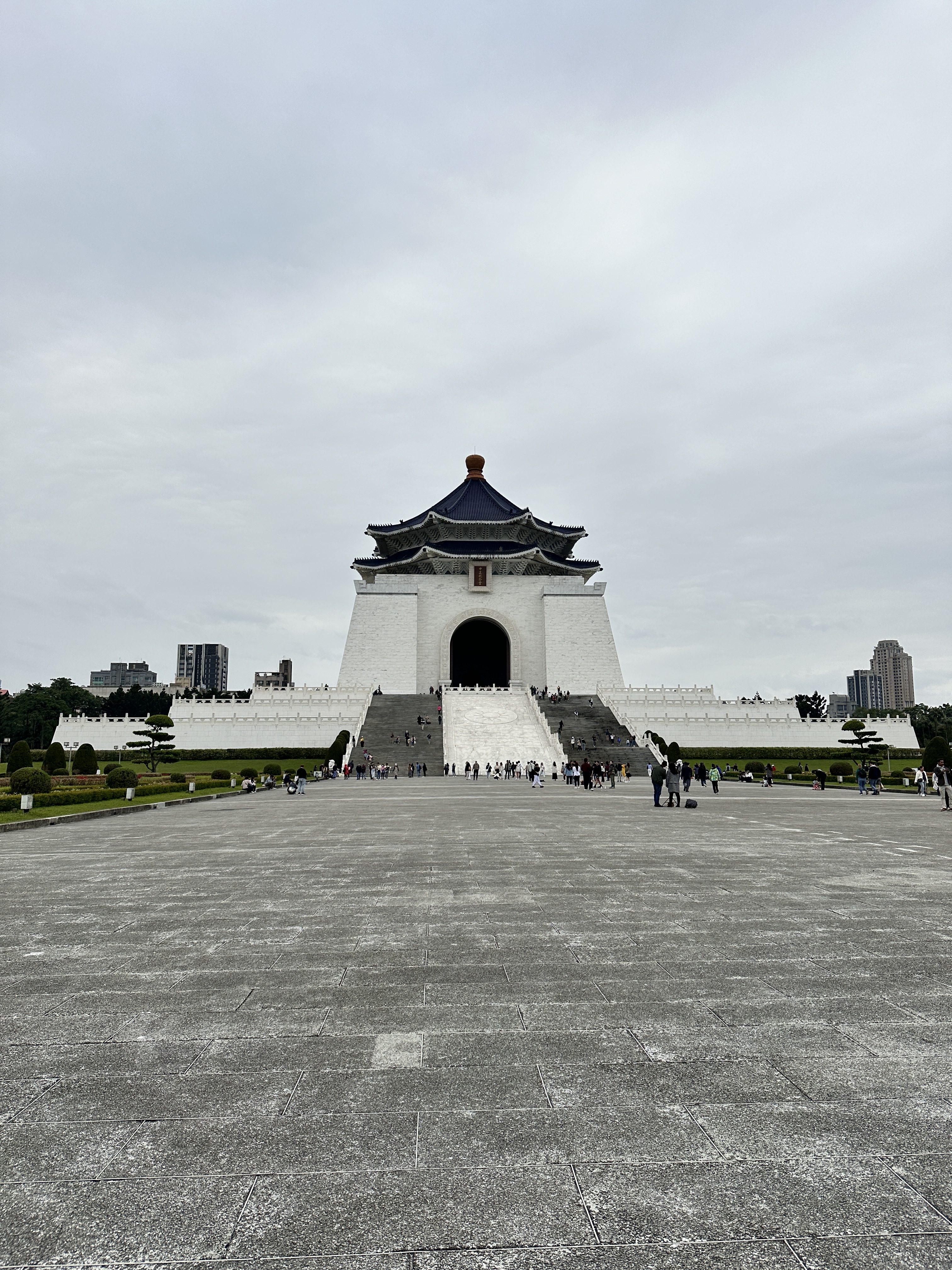 The Chiang Kai-shek Memorial Hall's front, featuring the white building with a blue roof and a wide plaza.