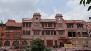 Navkar Mahal Pink City Jaipur. The structure features several windows with decorative grilles and an elevated roof adorned with small domes.