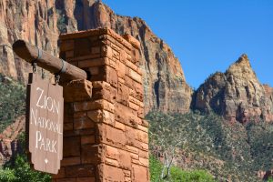 Zion national park sign board with mountains in the background