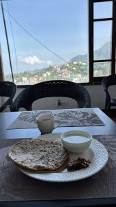 Two stuffed parathas with team front of a view of hill area.