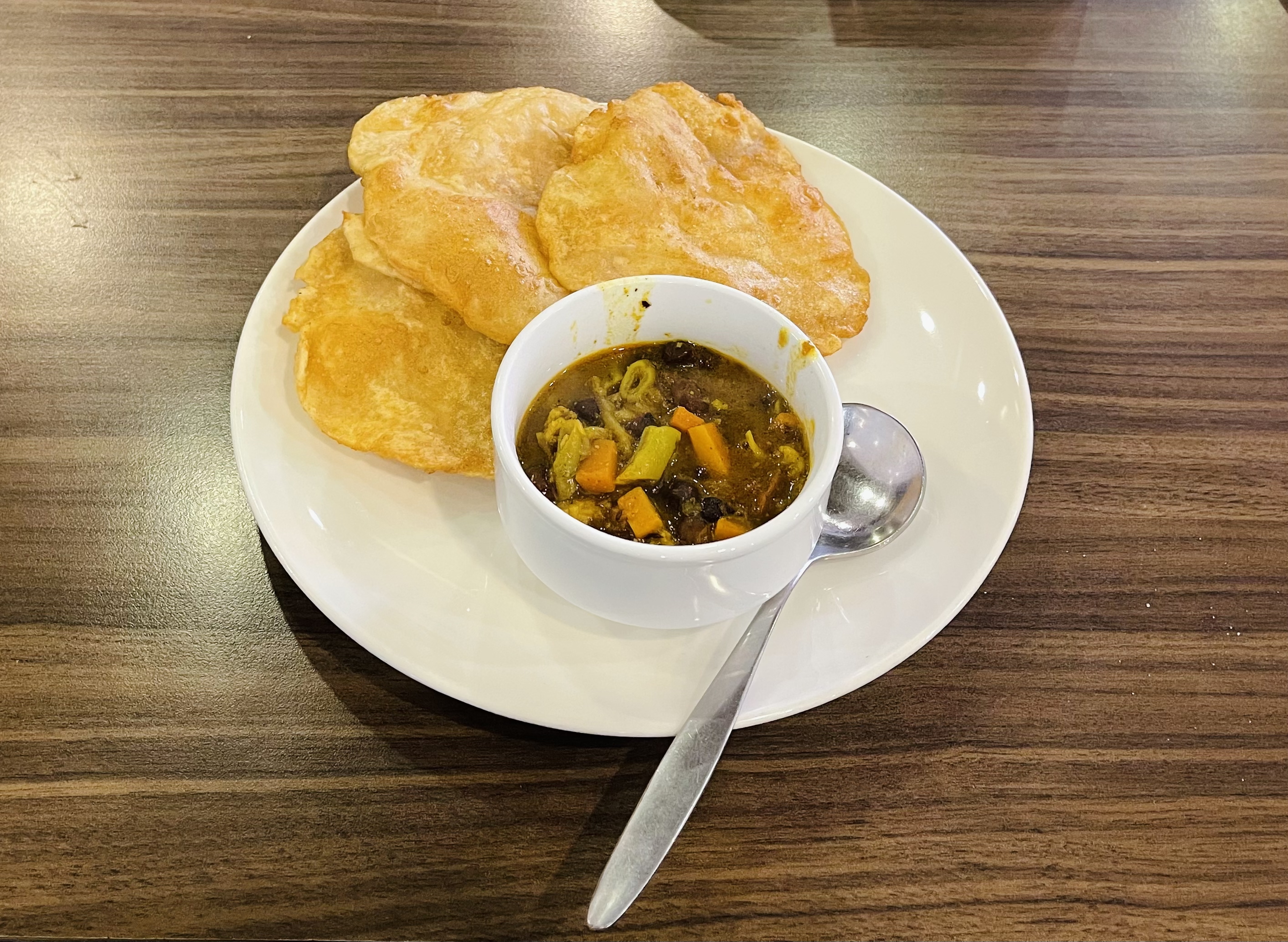 A plate of three fried pieces of bread and a bowl of stew.