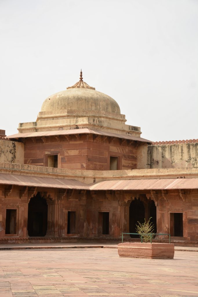 A sandstone courtyard pavilion crowned with a cream-colored dome, reflecting the elegance of Mughal design. Captured at Fatehpur Sikri, Uttar Pradesh.