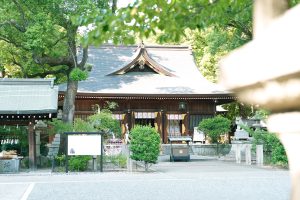 A traditional Japanese shrine surrounded by lush greenery, captured in soft daylight. Ideal for themes of spirituality, culture, heritage, and peaceful outdoor scenes.
