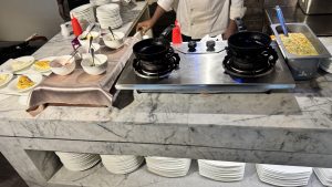 A marble countertop with a stainless steel cooking station is set up for food preparation.