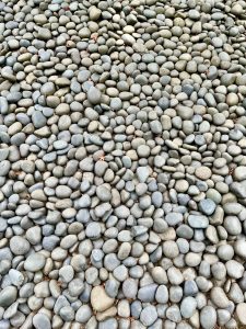 A close-up view of smooth black and grey pebbles neatly laid out on the garden path. Photo taken at Portland Japanese Garden, Oregon, USA. 