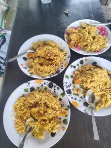 A table set with four plates of biryani, a traditional rice dish, each with a generous serving