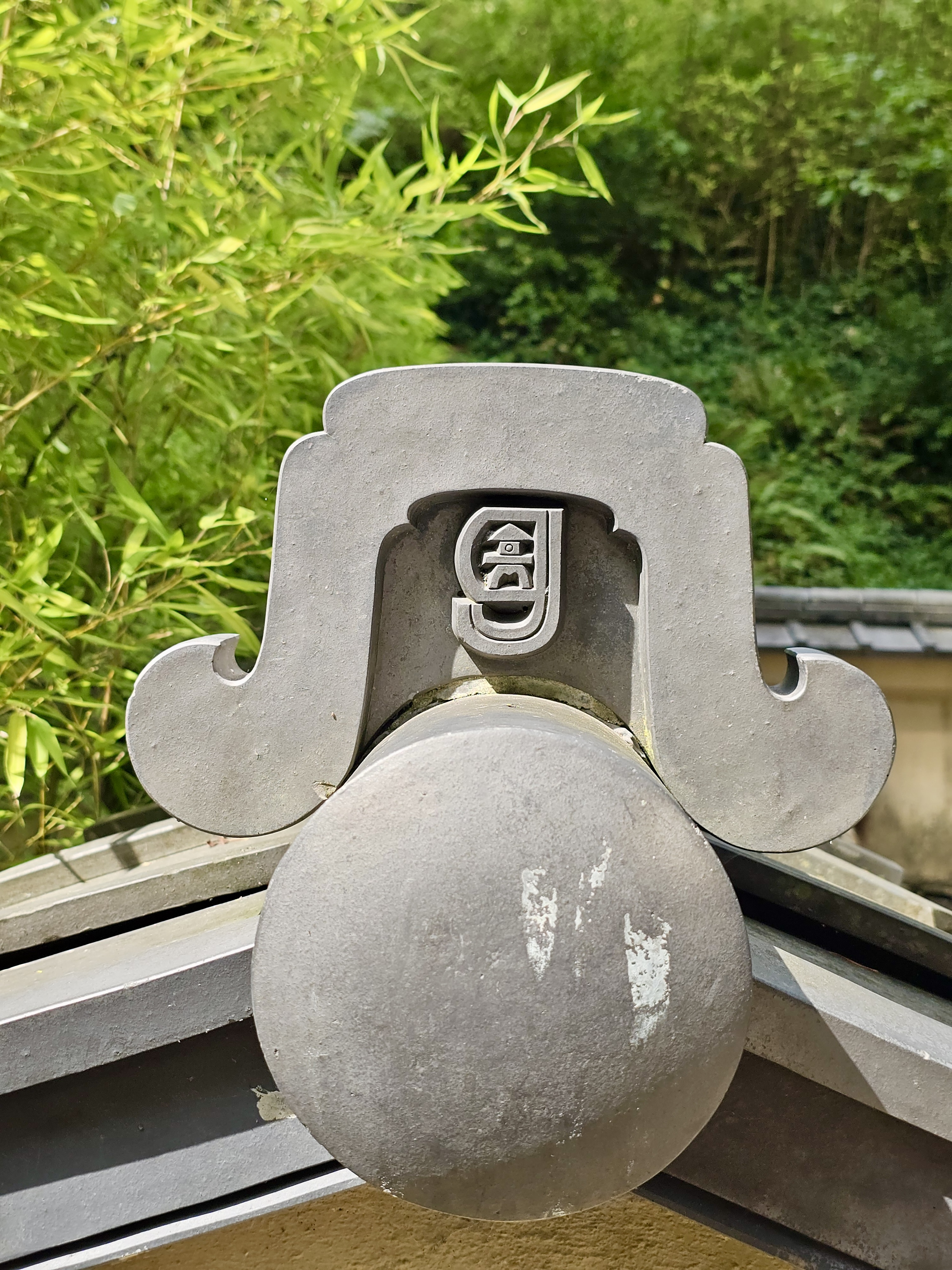 Ornamental rooftop tile with a carved symbol at the Portland Japanese Garden. A traditional Japanese design detail is seen near the entrance.