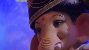 A close-up image of a decorative idol of Ganapati featuring distinctive features such as large ears, a trunk, and traditional adornments.
