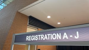 A sign over a desk labeled &quot;Registration A-J&quot;