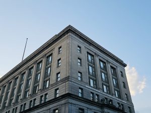 A corner view of the Pacific Northwest College of Art building, Portland, with a classical design, large windows, and a soft evening sky in the background.