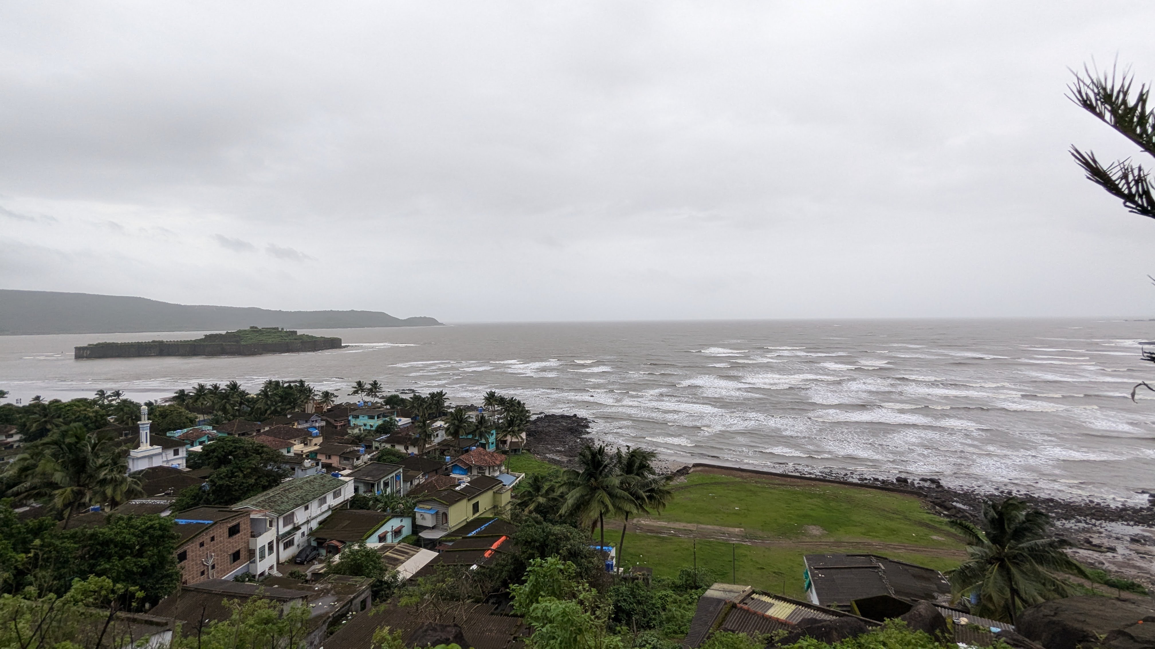 A coastal view showcasing a stormy sea with rolling waves under overcast skies.