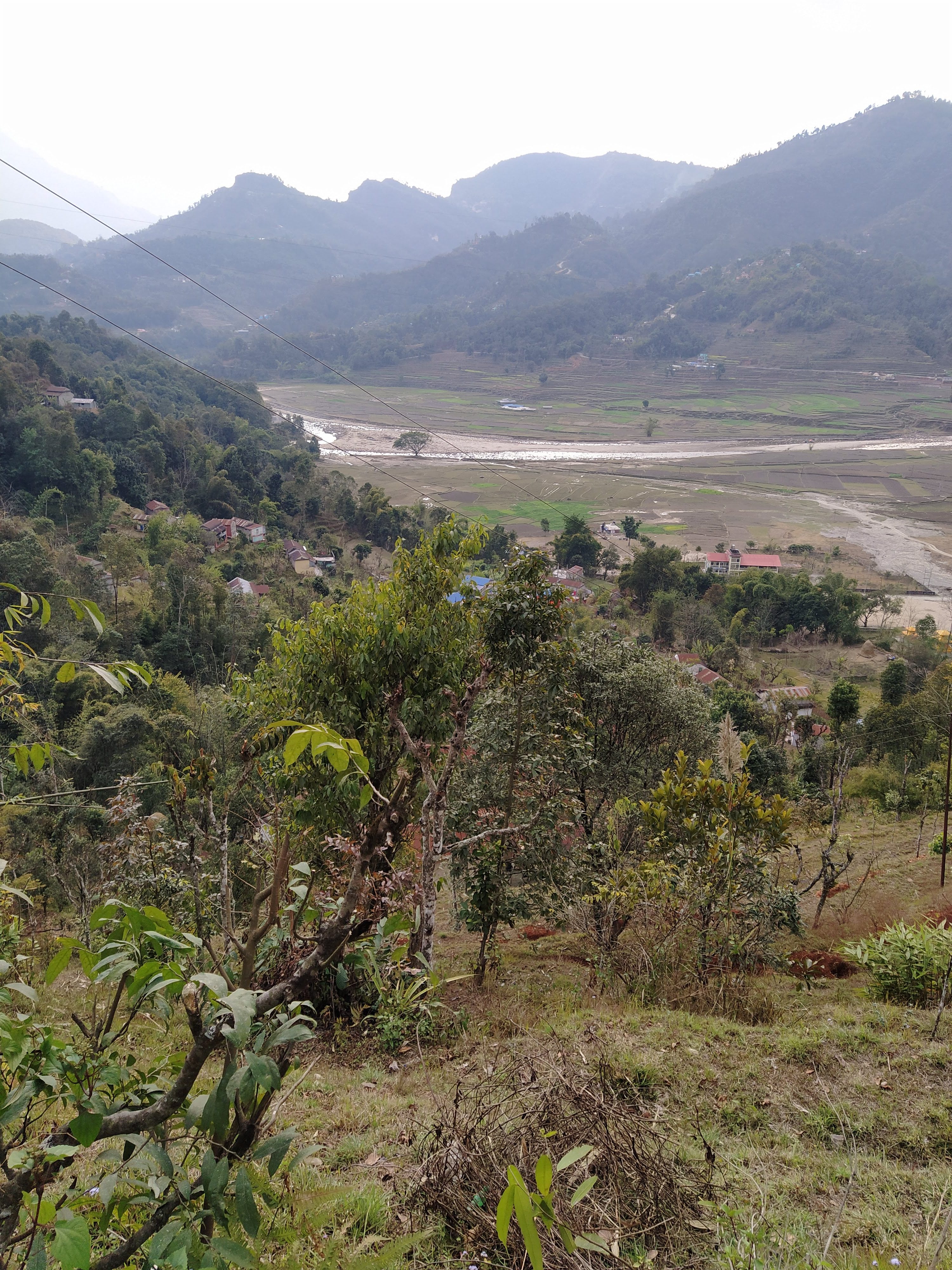 A scenic view of rolling hills and valleys, featuring a river winding through the landscape.