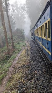 A misty landscape with a train passing along a narrow track. T
