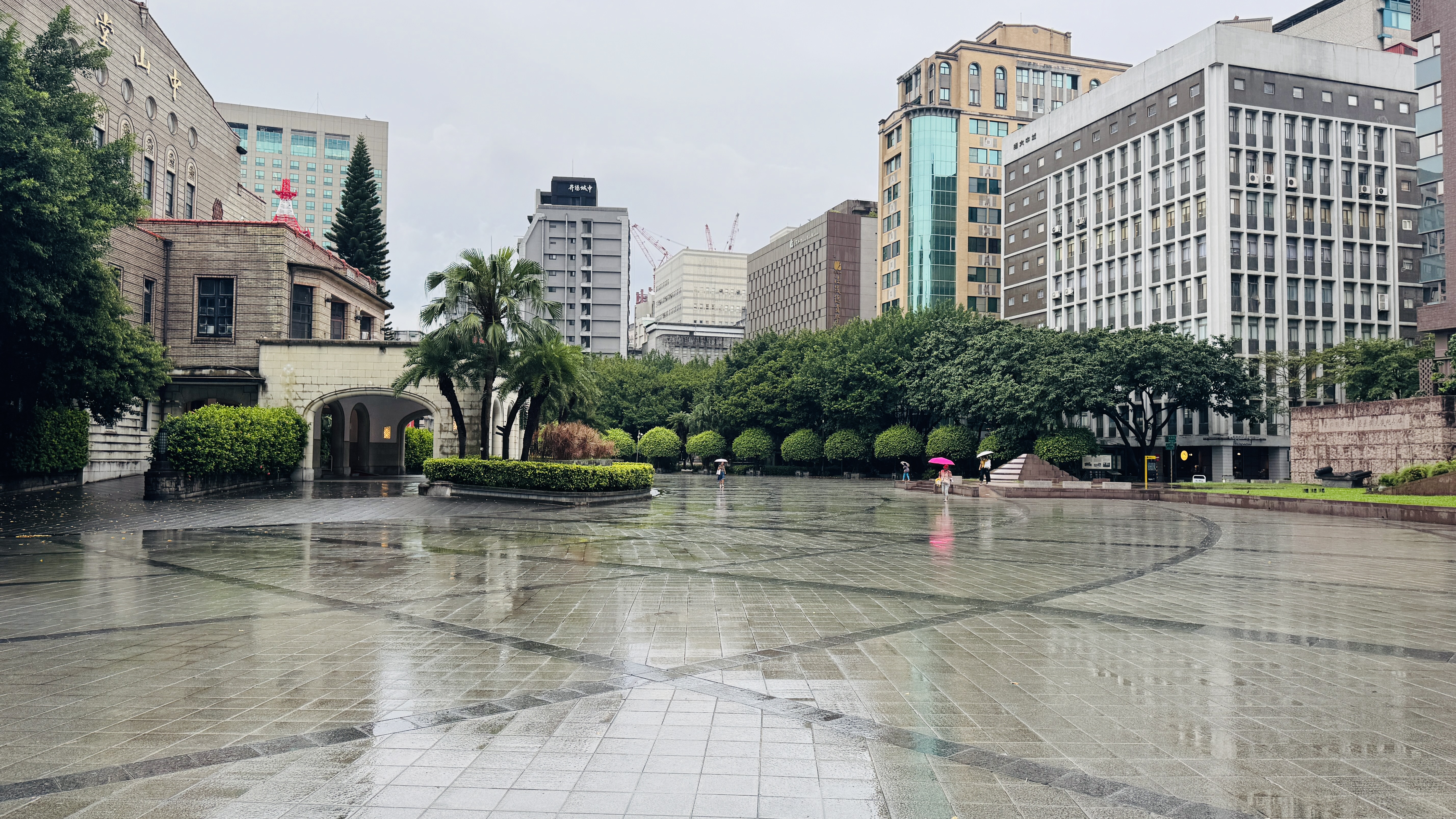 A wet plaza is depicted, featuring a mix of modern and older architecture