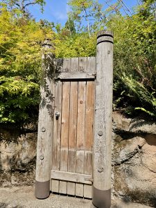 A small wooden gate with thick logs on each side, placed between garden paths at the Oregon Zoo, Portland.