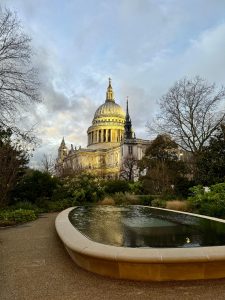St. Paul’s Cathedral rising behind trees and gardens, with a reflecting pool in front. 