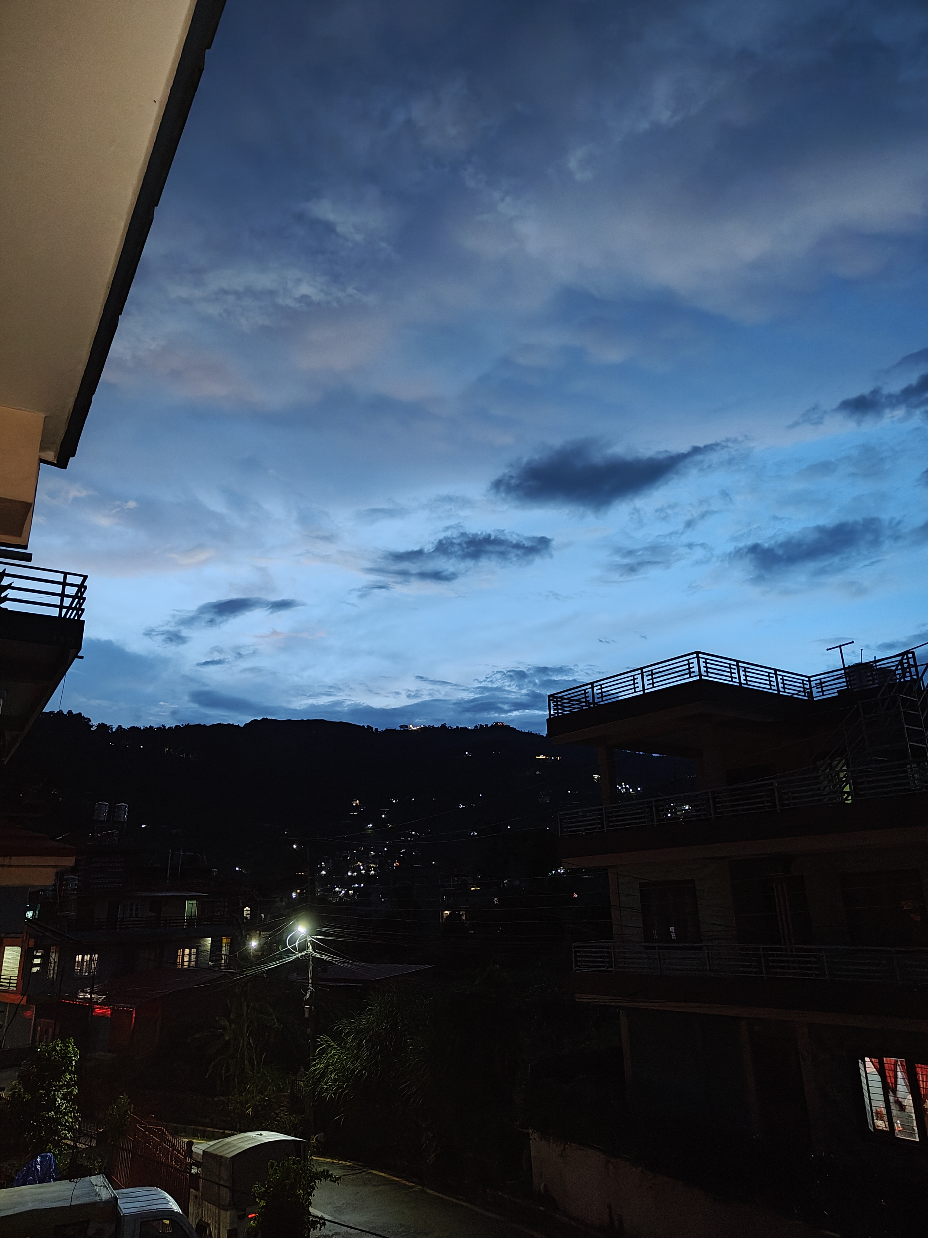 A twilight scene featuring a partially cloudy sky with blue and gray hues.