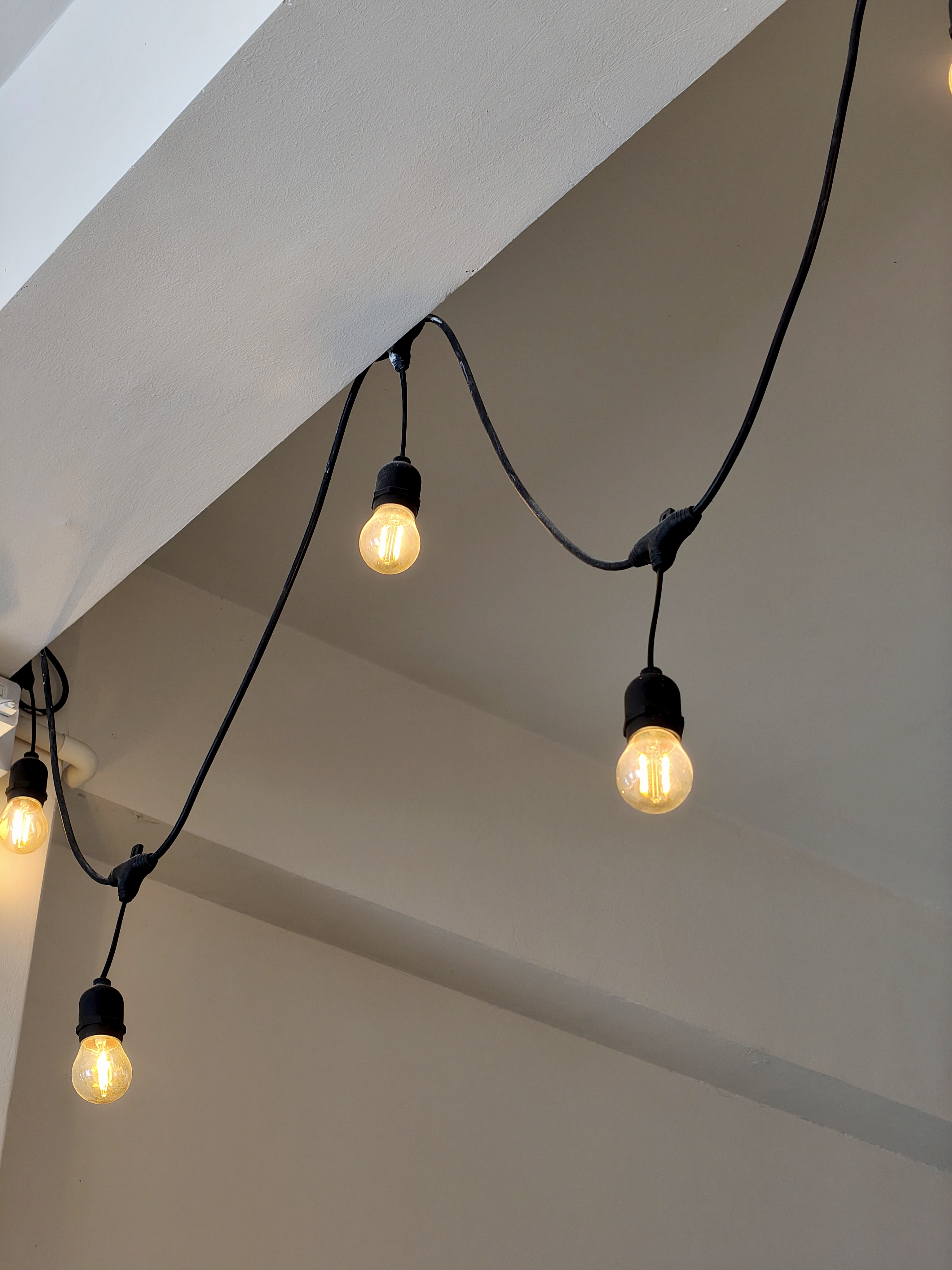 A close-up view of a string of vintage-style light bulbs hanging from a ceiling.
