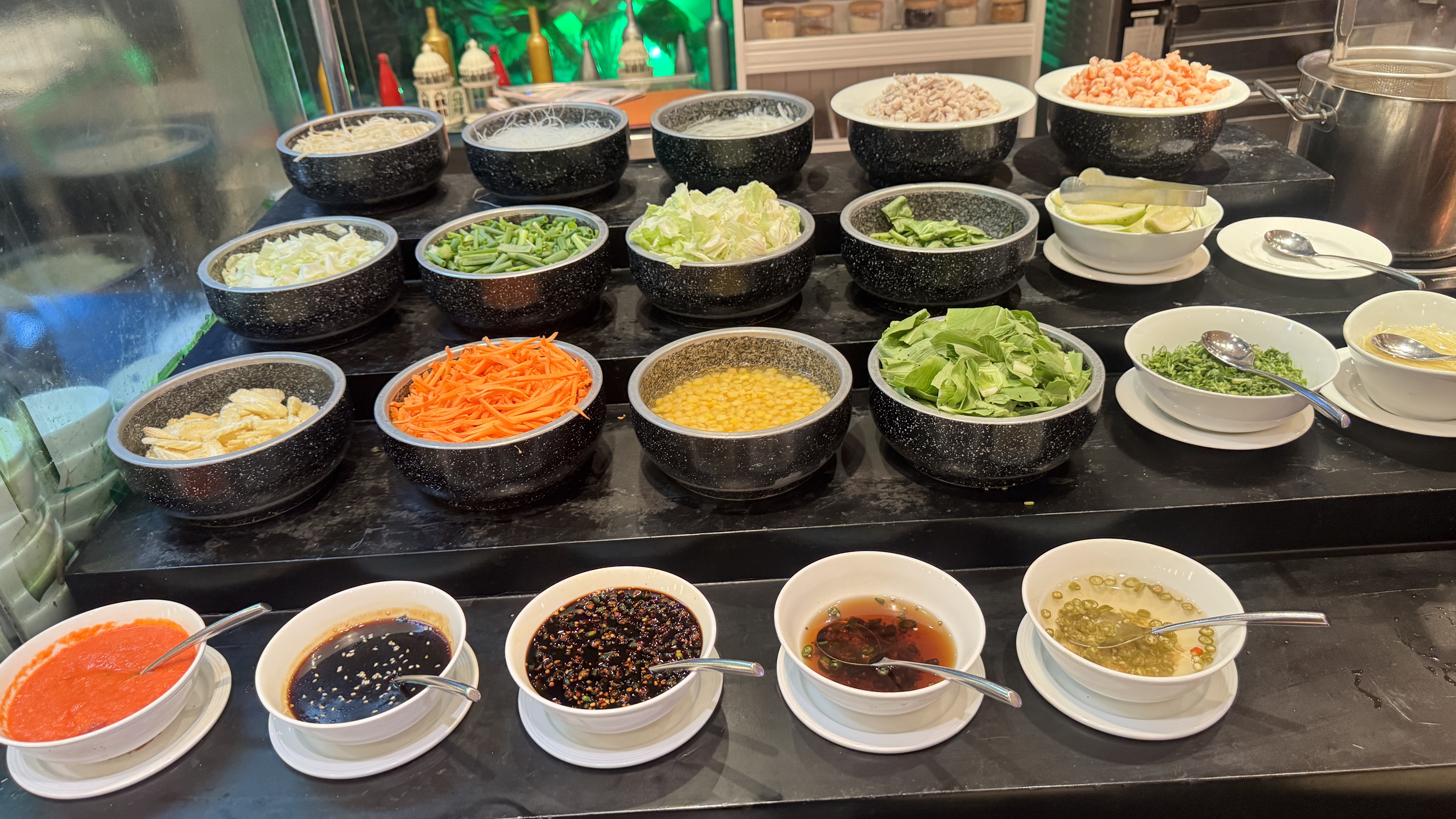 A variety of fresh ingredients arranged in bowls on a dark countertop. 