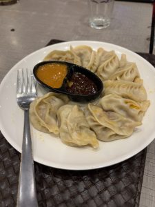 A plate of dumplings arranged neatly with a fork beside it. 