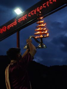 A person wearing a red traditional garment is performing a ritual.