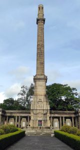 The Cenotaph War Memorial in Colombo features a tall stone pillar with a decorative finial, set in a landscaped area.