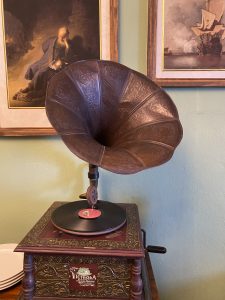 A vintage gramophone with an ornately designed horn sits atop a wooden base. 