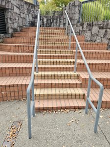 A brick stairway with metal handrails and gray stone walls at Washington Park, Portland. Captured in the evening with a clean geometric view. Useful for architectural or urban design themes.