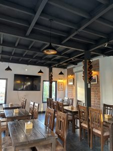 A cozy restaurant interior featuring wooden tables and chairs arranged neatly. 