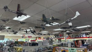 Amodel hobby shop filled with various scale model airplanes hanging from the ceiling