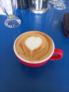 A heart shape in the foam on a cup of coffee.