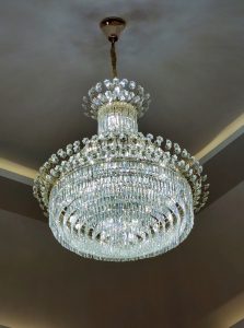 A large, ornate chandelier hangs from the ceiling, featuring multiple tiers of sparkling crystals arranged in a symmetrical pattern