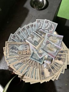 
A circular arrangement of various banknotes spread out on a flat surface.

