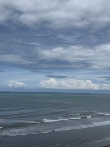 A serene coastal landscape featuring a calm ocean with gentle waves.
