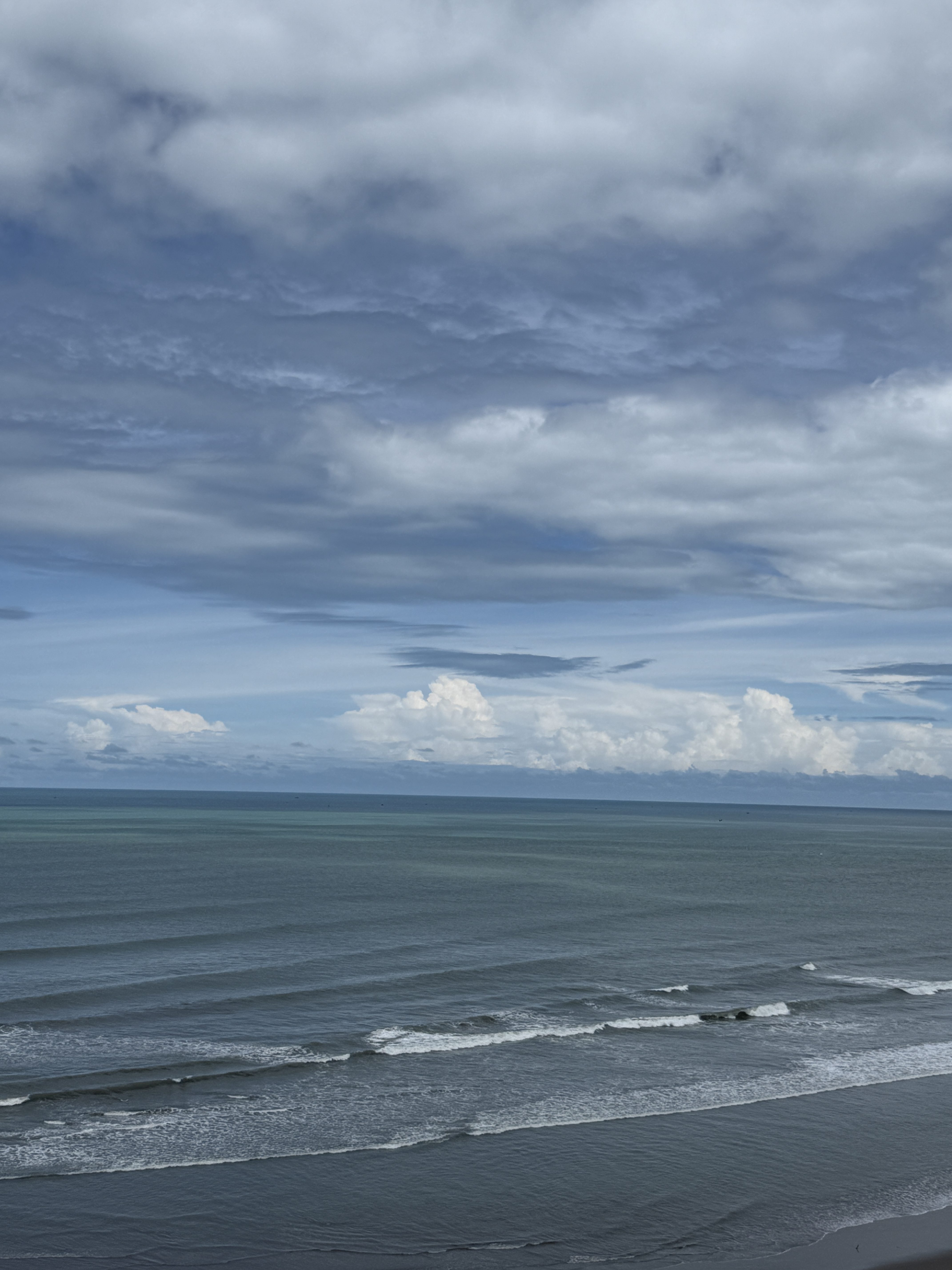 A serene coastal landscape featuring a calm ocean with gentle waves.