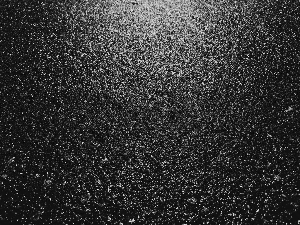 Wet black pavement with stark white reflected light.