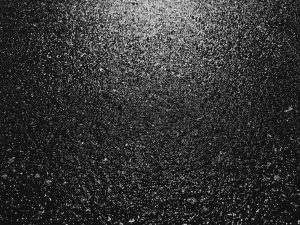Wet black pavement with stark white reflected light.
